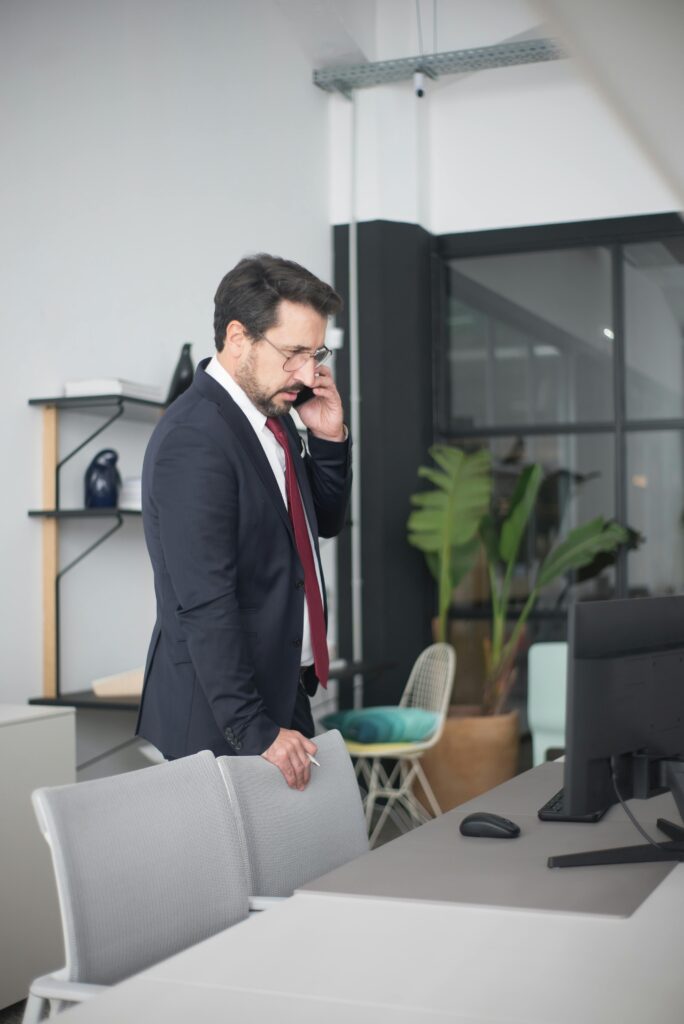 Businessman in a suit having a phone call in a contemporary office setting.